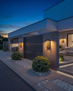 The Grandview Luxe outdoor wall sconce, wide dusk garage entrance shot