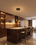 The Lumen Bar Pendant Chandelier glowing above a modern home bar counter